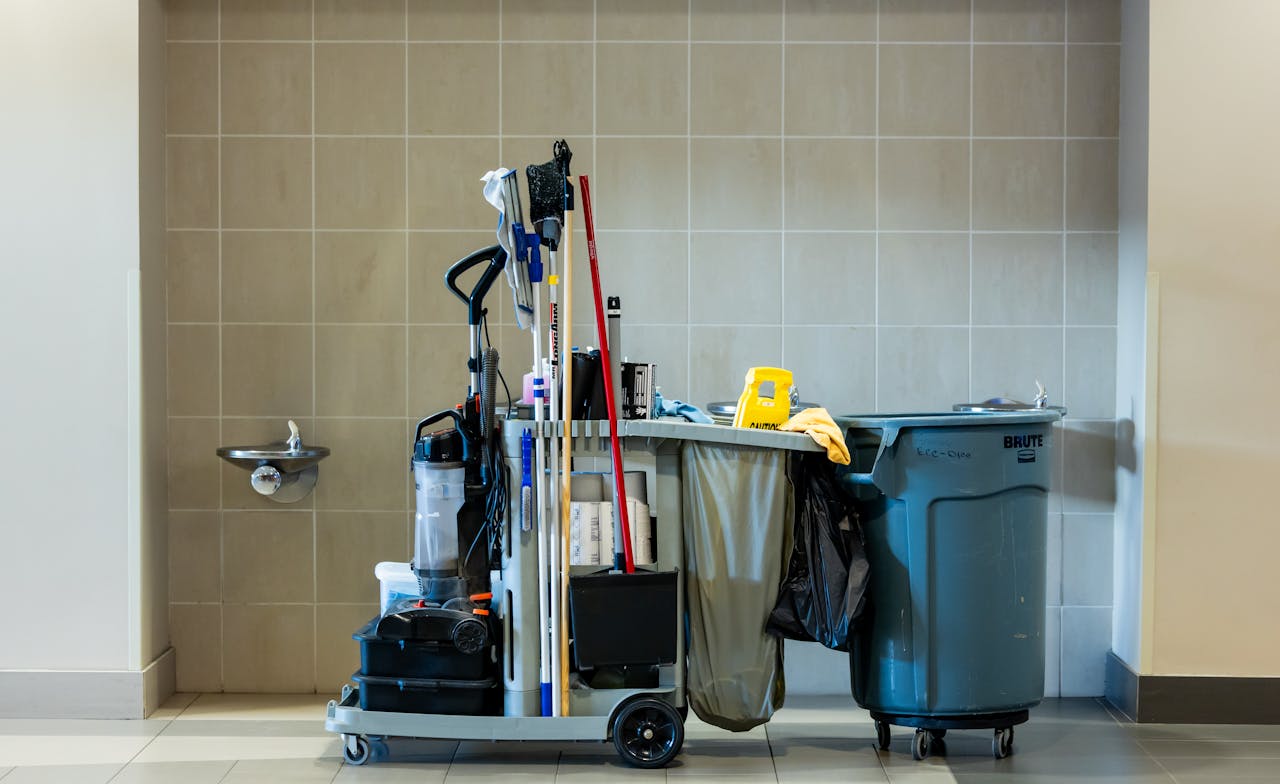 A comprehensive collection of professional cleaning tools on a cart in an indoor environment.